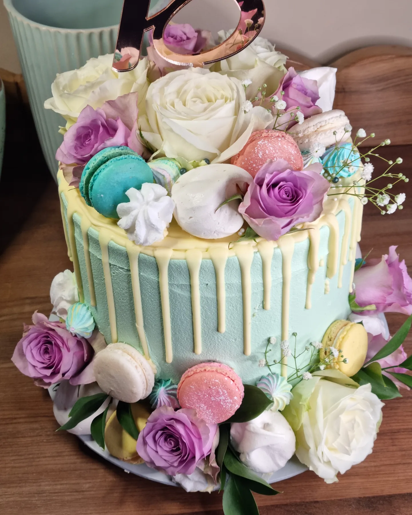A floral cake decorated with pastel macarons